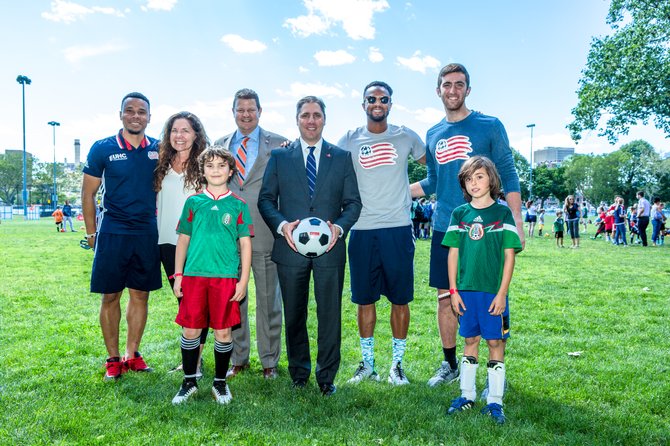 (De izq. a der.) El delantero de los New England Revolution Charlie Davies, y la directora ejecutiva de la Esplanade Association Tani Marinovich, Emi Alvarez (10 años) de Brookline, el vicepresidente senior de marca, medios y auspicios Jeff Greenler, el presidente regional de Santander Michael Bruno, Darrius Barnes defensa de los Revs, Matt Turner arquero de los Rves, y Ryder Feilke (10 años) de Brookline posan para una foto en el taller de fútbol organizado para lanzar el programa Santander Soccer Scholars.
