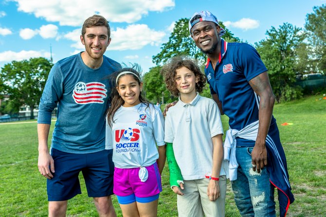 (De izq. a der.) El arquero de los New England Revolution Matt Turner, Scania Garcia Guzman (12) y Diego Fultz-Diaz (12) de The Hurley School, y el mediocampista de los Revs Gershon Koffie en la celebración del lanzamiento del programa Santander Soccer Scholars.
