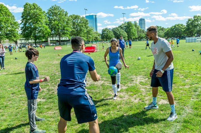 Estudiantes de The Hurley School, Yanifred Galarza (13 años) y David Wetzel (13 años) practican fútbol con Charlie Davies y Darrius Barnes en la celebración del lanzamiento del programa Santander Soccer Scholars.
