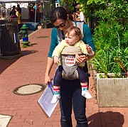 Una mujer carga a su hijo durante la campaña a favor de la Ley de Permiso de Trabajo Remunerado en el Distrito de Columbia.