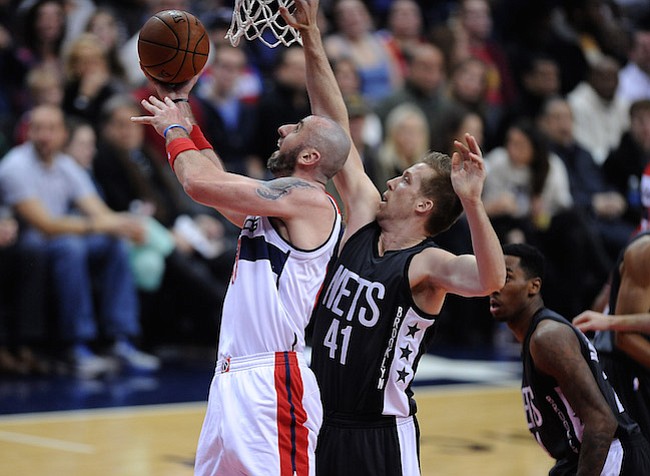 Washington D.C. -December 30, 2016: Marcin Gortat de los Washington Wizards se eleva con el balon para anotar en la canasta contra Justin Hamilton de los Brooklyn Nets. Los Washington Wizards derrotaron a los Brooklyn Nets 118-95 en un partido de la temporada regular en la arena de el Verizon Center.