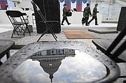 El capitolio de los Estados Unidos se refleja en un charco del agua en una silla mientras que la gente ensaya el domingo para la inauguración de Donald Trump.