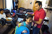 Giovani Jiménez, a la derecha, cepilla el cabello de su hija Lucía mientras Alex espera para ir a visitar a Uruchi en la cárcel regional Virginia Peninsula en septiembre. Ella será deportada esta semana.

