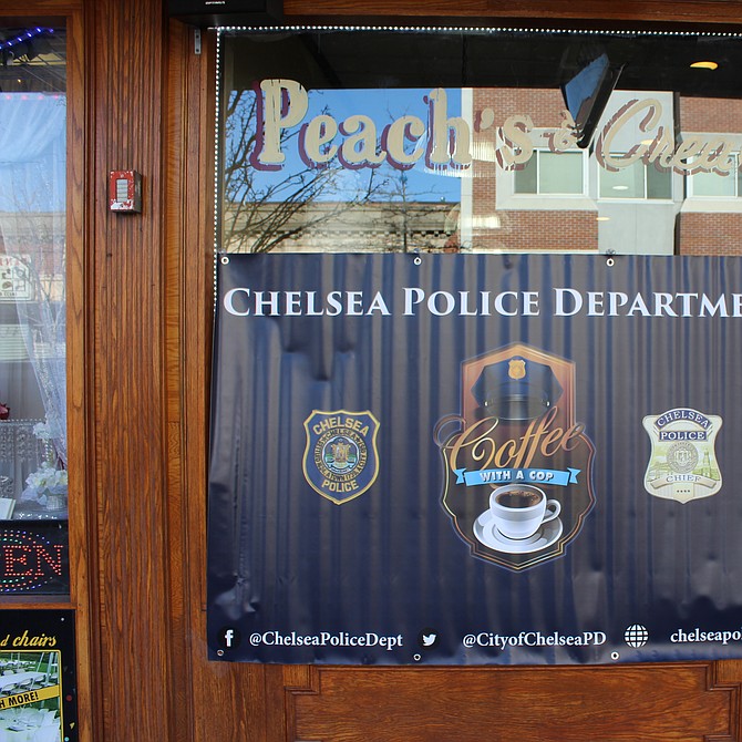 Banner de la convocatoria al evento en la puerta de la pastelería Peaches and Cream