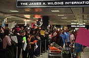 La gente protesta y da la bienvenida a los pasajeros que llegan al Aeropuerto Internacional Washington Dulles.