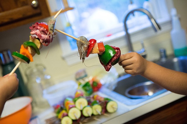 Hermanas batallando con pinzas de cocina mientras ayudan a sus padres a preparar una cena del Día de la Madres en la casa que comparte con su familia en el norte de Virginia. Los padres de las hermanas están indocumentados y recientemente arreglaron la custodia de sus hijas, 7 y casi 2 años, quienes son ciudadanas americanas