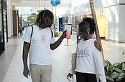 Maya Terrell, a la derecha, camina con Lamarr Morris en el centro comercial Arden Fair de Sacramento el 19 de junio. 