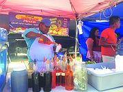 MULTISABORES. Elías Arias prepara uno de las "piraguas" en su negocio en la Liga de Langley Park.
