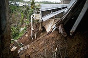 Un derrumbe de las inundaciones del huracán María se ve en la parte posterior de una casa dañada en Barranquitas, Puerto Rico, el 18 de octubre de 2017.