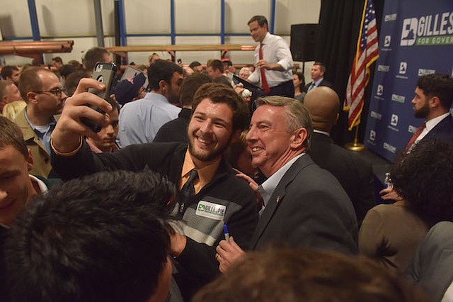 El Senador Marco Rubio, Republicano por Florida, en el fondo en una concentración a favor del candidato del GOP por Virginia, Ed Gillespie, el lunes en Saterling, Virgina. Adentro, rodeados por simpatizantes, Gillespie habló acerca de todo lo que tenía en común con Rubio, un candidato presidencial de 2016 popular en los suburbios del norte de Virginia.