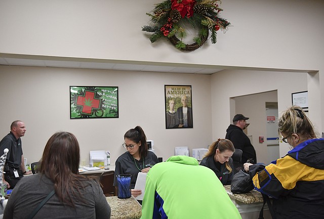 Los pacientes se registran en el mostrador con el personal de la oficina en el dispensario de marihuana medicinal Allegany en Cumberland, Md.
