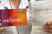 Rebeca González sostiene una copia de su recibo y su tarjeta de lealtad del mercado Northgate. La tarjeta registra los gastos de González en productos frescos y sanos, para luego darle su recompensa en forma de más dólares para comprar productos saludables.