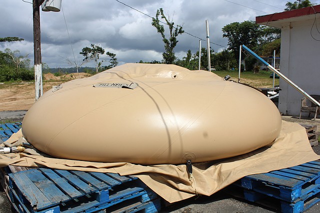 Una unidad de almacenamiento de agua sobre una base de madera en una calle de Utuado, Puerto Rico, en las montañas del centro de la isla. FEMA compró 161 de estos depósitos luego del huracán María.