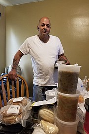 Feliciano Pagan, beneficiario de Medicaid en Philadelphia, junto a sus comidas médicamente diseñadas preparadas por la organización sin fines de lucro MANNA y pagadas por Health Partners Plans, su plan de salud de Medicaid.