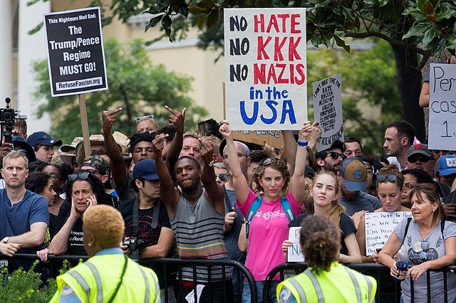 EE.UU. Contramanifestantes detrás de una línea policial señalando a los supremacistas blancos durante el mitin de Unite the Right en Lafayette Park en Washington, DC.