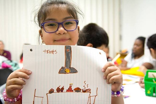 Manualidades. Una pequeña estudiante que asiste al programa Kids Club muestra su trabajo manual que hizo en Casa Chirilagua.