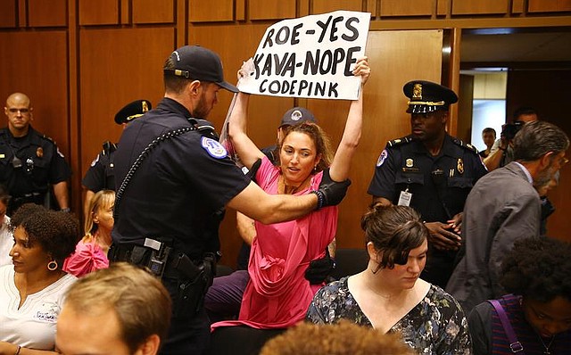 PROTESTA. Una mujer interviene mientras el conservador Brett Kavanaugh se dispone a testificar al comienzo de las audiencias celebradas para su confirmación, el martes 4 de septiembre