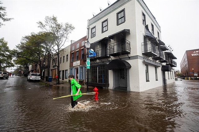 Vecinos caminan por una calle inundada tras el paso del huracán Florence, en Wilmington