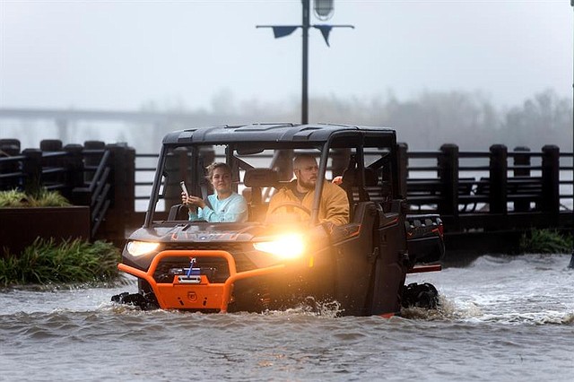 CLIMA. Dos vecinos circulan por una calle inundada tras el paso del huracán Florence, en Wilmington, Carolina del Norte, EE.UU.