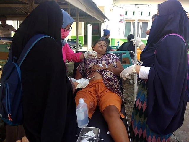 INDONESIA. Una persona es ayudada tras el primer sismo