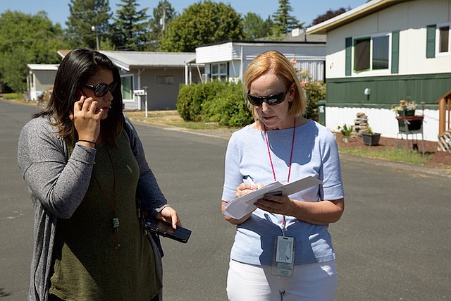 Mary Horman (derecha), enfermera certificada del condado de Clackamas, en Oregon, y Liz Baca, especialista en intervención de enfermedades del condado, buscan la dirección de una de las personas que deben visitar como parte de su trabajo. Ellas visitan a parejas sexuales de personas diagnosticadas con enfermedades de trasmisión sexual, para que se hagan pruebas y eventualmente reciban tratamiento.