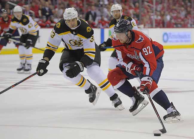 TRIUNFO. El centro de los Capitals Evgeny Kuznetsov (92) avanza hacia la red contra el defensa Zueno Chara (33) de los Bruins, durante el primer juego de la franquicia capitalina en la temporada NHL. Kuznetsov tuvo dos goles cuando Washington derrotó a Boston, 7-0, el miércoles por la noche.