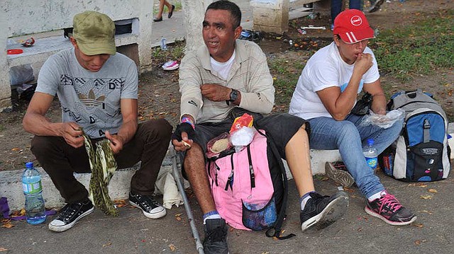 MIGRACIÓN. Geovanni (al centro) toma un pequeño descanso con un par de salvadoreños que también forman parte de la caravana