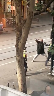 Captura de vídeo que muestra a un hombre armado con un cuchillo mientras se enfrenta a los agentes después de atacar a varias personas en la calle Bourke de Melbourne