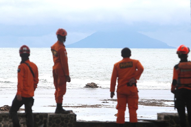 Miembros de los servicios de rescate observan el volcán Anak Krakatau desde la playa Carita en Indonesia, el miércoles 26 de diciembre de 2018