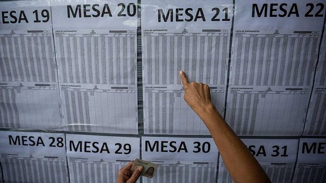ELECCIONES. Foto de una persona mientras verifica sus datos para votar en El Salvador