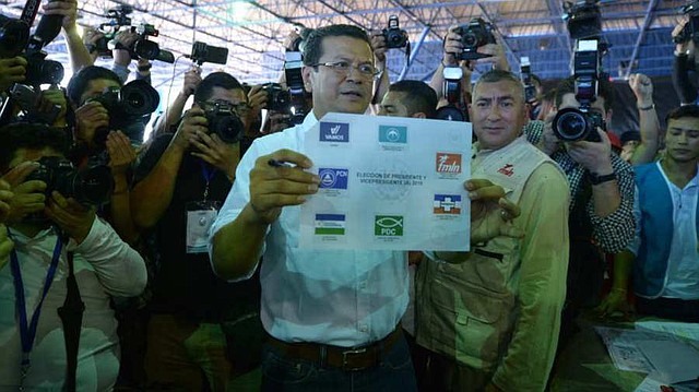 Hugo Martínez, candidato del FMLN, muestra su papeleta antes de emitir el sufragio en el centro escolar Concha viuda de Escalón.