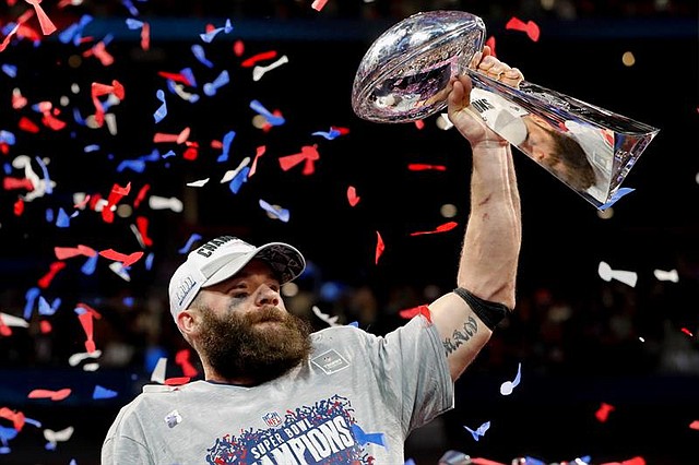 El receptor de los New England Patriots, Julian Edelman, sostiene el trofeo