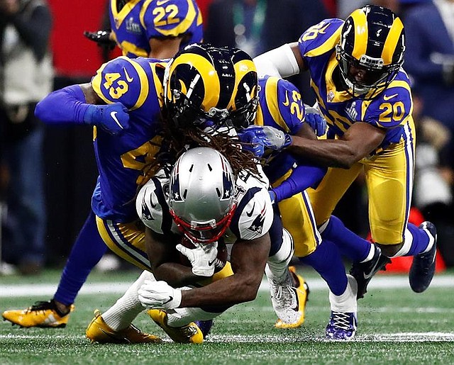 El receptor abierto de los New England Patriots, Cordarrelle Patterson (C), es atacado por la fuerte seguridad de los Angeles Rams John Johnson (L), el defensa de Los Angeles Rams Nickell Robey-Coleman (Top-C) y la seguridad gratuita de los Angeles Rams Lamarcus Joyner (R) durante la primera mitad en el estadio Mercedes-Benz en Atlanta
