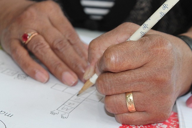 ESCRITURA. Una de las estudiantes llena un crucigrama que le enseña a diferenciar la palabra mano de la palabra mono.