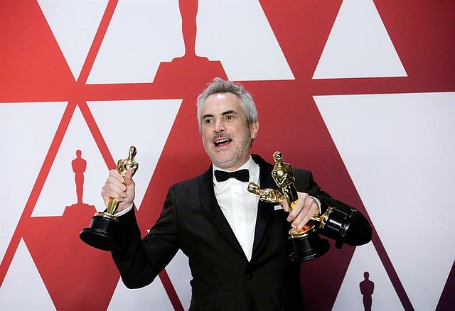 CINE. Alfonso Cuarón posa con las tres estatuillas de "Roma": mejor dirección, mejor fotografía y mejor película de habla extranjera en los Óscar 2019.