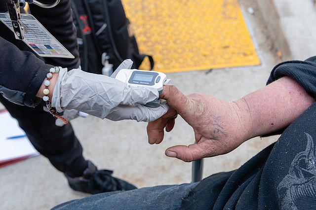 La asistente médica Negeen Farmand, de Sabam Community Clinic, chequea los signos vitales de Jennifer Millar en el campamento de personas sin techo en la autopista de Hollywood.