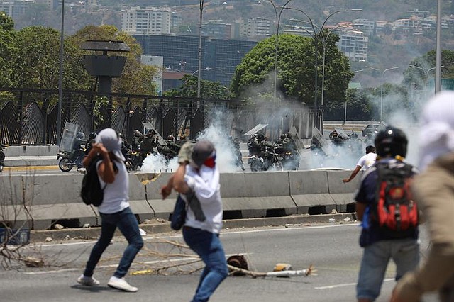 REPRESIÓN. Manifestantes opositores se enfrentan con miembros de la Guardia Nacional Bolivariana en las calles de Caracas este miércoles.