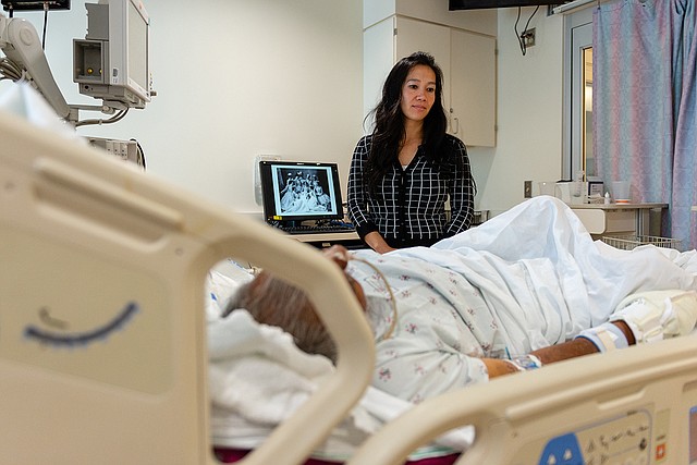 Lenh Vuong, trabajadora clínica social de Los Angeles County+USC Medical Center, visita a un paciente que ingresó sin nombre y que recientemente fue identificado.