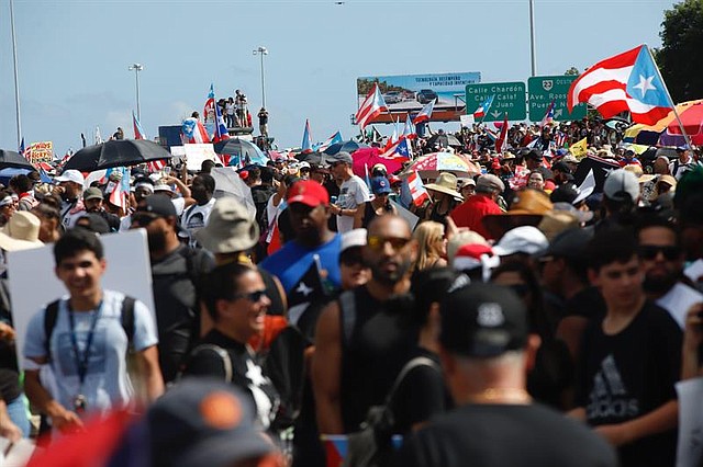 CRISIS. Cientos de personas participan este lunes en una marcha masiva en San Juan