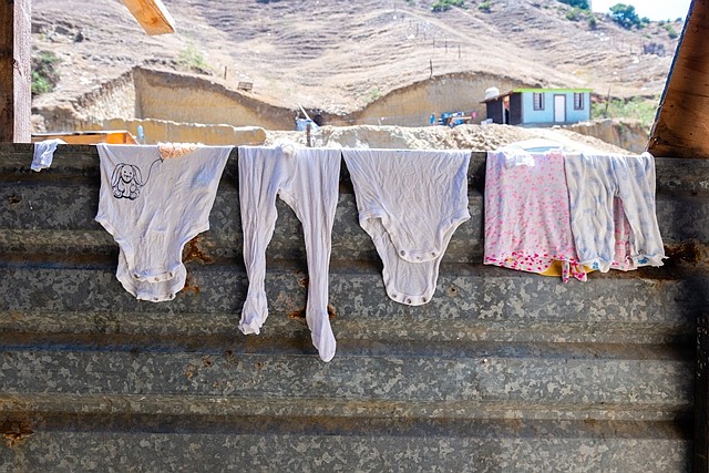 La ropa de bebé se seca en el refugio Camino de Salvación, que es el hogar de familias con niños. El refugio está ubicado a unos 20 minutos de la frontera, en el barrio El Pipila de Tijuana, al final de un largo camino de tierra. El acceso a agua y electricidad es limitado. Todos los migrantes comparten dos baños, cada uno con algunas casetas. (Heidi de Marco/KHN)