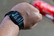 Ali, director interino en el Microsoft Technology Center, en Irvine, California, monitorea los niveles de glucosa de su hijo Sam, quien tiene diabetes tipo 1, usando un sistema de circuito cerrado casero en su reloj inteligente. Este sistema conecta la bomba de insulina con un monitor de glucosa, y un software de código abierto libera diferentes dosis de insulina. (Heidi de Marco/KHN)