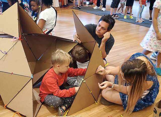 AMBIENTE. Una familia construye la casa imaginaria de un futuro sostenible, con pedazos de cartón.
