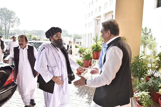 El ministro de Relaciones Exteriores de Pakistán, Shah Mehmood Qureshi (derecha), mientras saluda al cofundador y líder político del movimiento talibán Mullah Abdul Ghani Baradar (2-derecha) durante su reunión en Islamabad, el jueves 3 de Octubre de 2019. | Foto: Efe.
