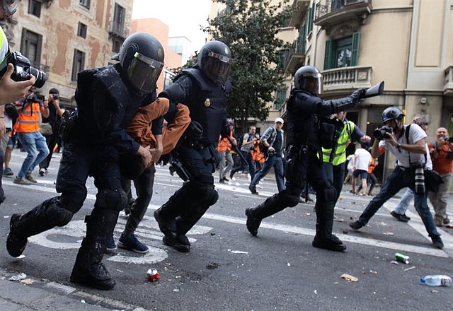Momento en el que agentes de la Policía Nacional detienen a un joven durante disturbios registrados en la Via Laietana, en Barcelona, el viernes 18 de octubre. | Foto: Efe/Enric Fontcuberta