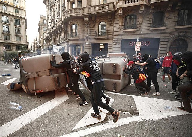 PROTESTAS. Manifestantes atravesaron obstáculos en la Via Laietana mientras se enfrentaban a los policías. | Foto: Efe/Jesús Diges