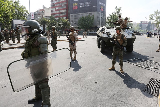 PROTESTAS. Militares bloquean las manifestaciones contra el incremento del precio en los boletos del Metro, el sábado 19 de octubre en Santiago. | Foto: Efe/Elvis González.