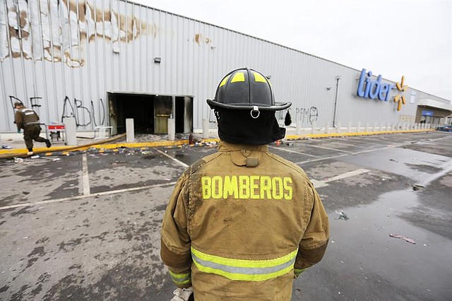SINIESTRO. Bomberos trabajan en el supermercado de la cadena Walmart, que resultó quemado y saqueado durante las manifestaciones este domingo. | Foto: Elvis González