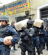 GOLPE. Agentes policiales incautan armas, dinero y droga después de capturar a una treintena de presuntos miembros del cártel Unión Tepito.