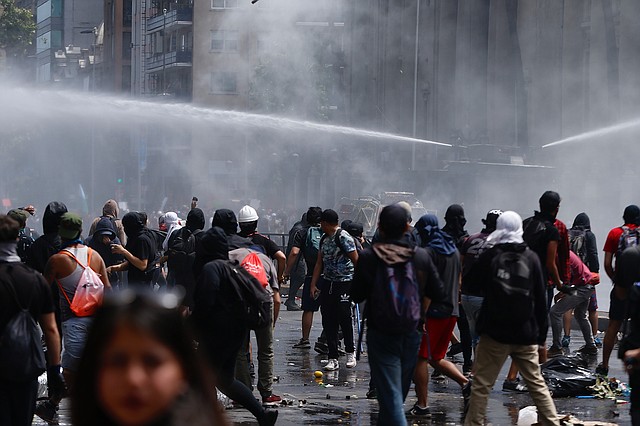 DISTURBIOS. Funcionarios de seguridad de Chile reprimen las manifestaciones con bombas lacrimógenas y vehículos antimotines. | Foto: Efe/Alberto Valdes.