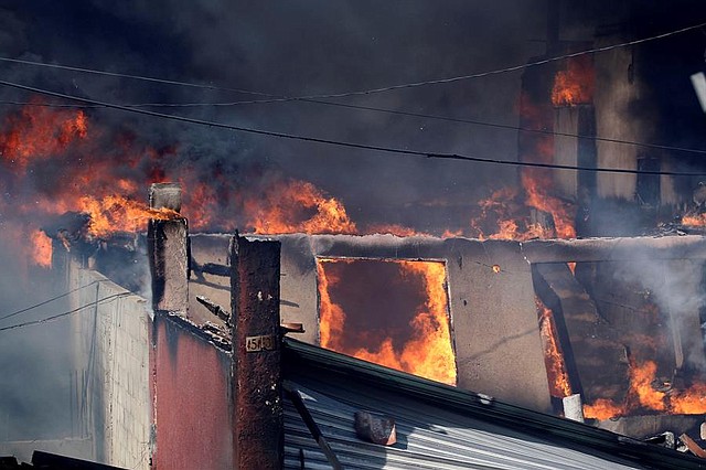 INCENDIOS. Vista general donde un incendio de pastizales alcanzo viviendas este viernes, en la ciudad de Tijuana, en el estado de Baja California (México). El estado mexicano de Baja California, noroeste de México, fue impactado en los últimos dos días por la condición climática Santa Ana, informaron este viernes autoridades